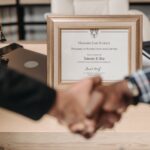 Harvard Law School degree with handshake representing achievement and professional agreement.