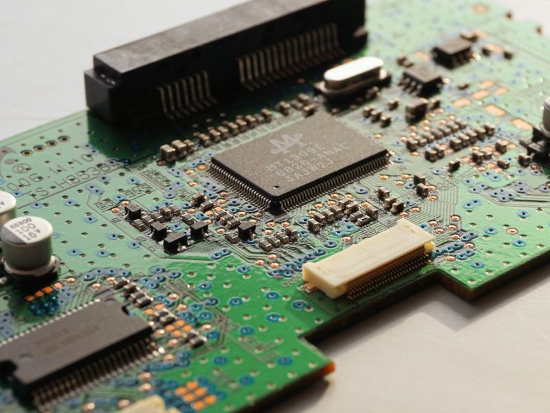 Detailed close-up photo of a circuit board highlighting microchip components and electronic circuits.
