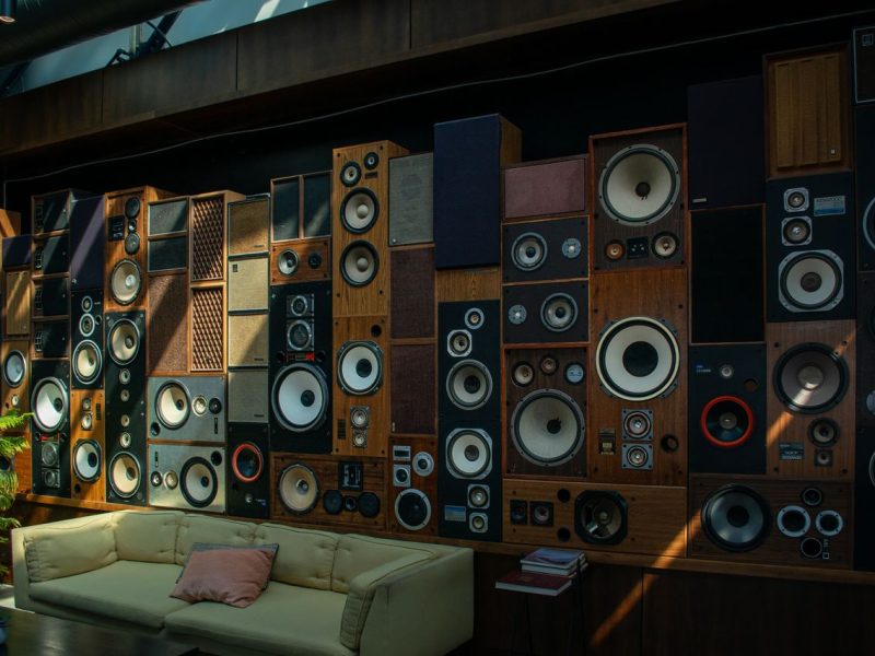 A cozy living room with a striking wall of vintage speakers, showcasing retro audio aesthetics and comfortable seating.